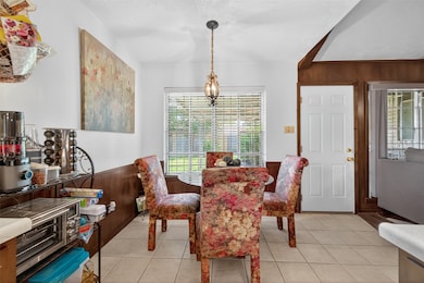 Breakfast nook with a large window framing serene backyard views, perfect for morning coffee and casual dining.