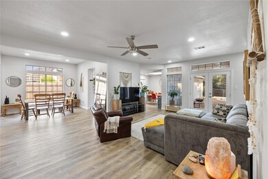 Living room with ceiling fan, french doors, light 