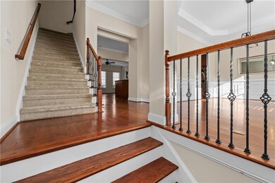 Staircase featuring ceiling fan, crown molding, an
