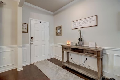 Foyer entrance featuring dark hardwood / wood-style flooring and ornamental molding