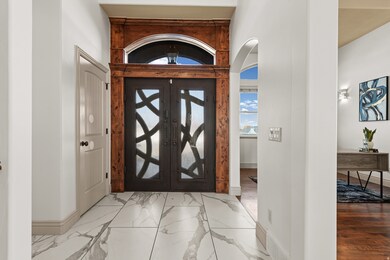 Entrance foyer featuring arched walkways, marble finish flooring, and french doors