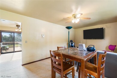 Carpeted dining space featuring ceiling fan