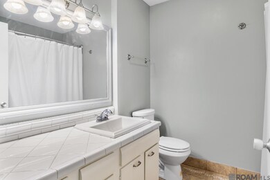 Decorator Tile Flooring ~ Framed Mirror ~ Updated Vanity Light ~ Refinished Tub & Surround ~ Updated Toilet, Hardware & Faucet