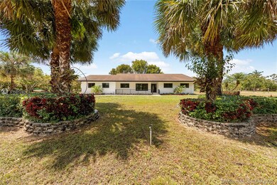 FRONT VIEW OF HOME BETWEEN THE PALMS.