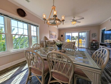 Dining area with ornamental molding, a chandelier, dark wood-type flooring, a ceiling fan, and a textured ceiling