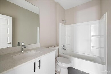 Full bath with toilet, tile patterned floors, vanity, and shower / washtub combination