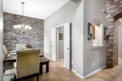Formal dining room is just to the left of the entry and has a beautiful brick accent wall.