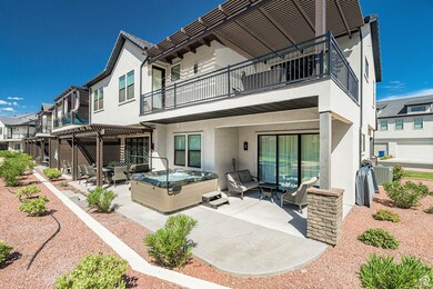 Back of house featuring a patio area, a hot tub, stucco siding, a pergola, and outdoor lounge area