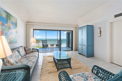 Living room with a water view, light tile patterned floors, and a textured ceiling