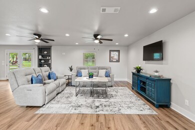 Living area with a ceiling fan, baseboards, plent