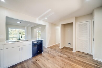 Kitchen featuring black dishwasher, white cabinetr