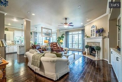 Living room featuring crown molding, dark wood-style flooring, a tile fireplace, ceiling fan, and recessed lighting