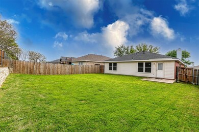 Back of property with a fenced backyard, a patio, a yard, and a chimney