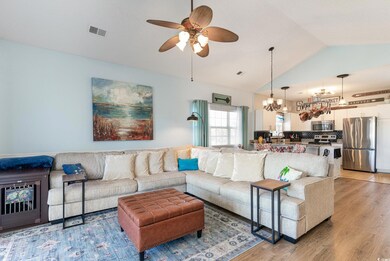 Living area with visible vents, ceiling fan with n