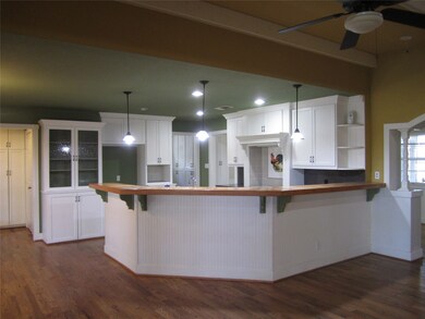 OPEN KITCHEN TO LIVING ROOM FEATURES A BREAKFAST BAR, CUSTOM CABINETS, RECESSED LIGHTS, BEADED WAINSCOTING, BUTLERS PANTRY AND MORE