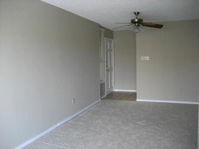 Carpeted empty room with a ceiling fan and basebo