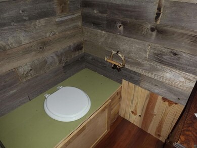 Bathroom with toilet and hardwood / wood-style flo