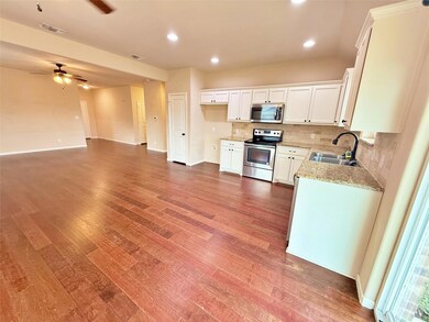 Kitchen with ceiling fan, appliances with stainless steel finishes, decorative backsplash, white cabinets, and sink