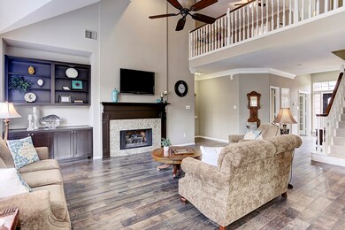 Another view of the living room shows off the stately fireplace with granite tiles, framed by an extensive mantle painted in deep espresso.  Adjacent to the fireplace, you'll find great built-ins with cabinets ready to hide all of your wires and electronic components.