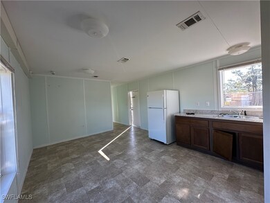 Kitchen featuring dark brown cabinetry, white fridge, and sink