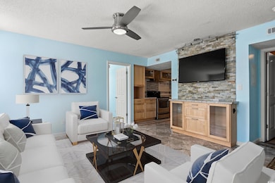 Living area featuring a textured ceiling and ceiling fan