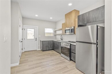 Kitchen with stainless steel appliances, a sink, modern cabinets, light countertops, and recessed lighting