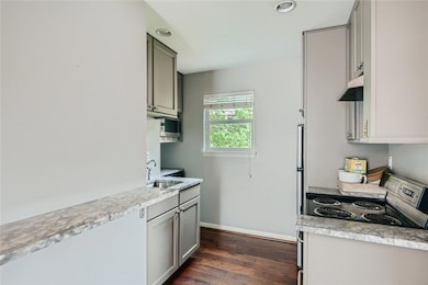 Kitchen with a sink, gray cabinets, light counter