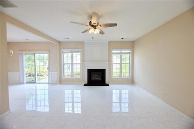 Unfurnished living room featuring a ceiling fan, a
