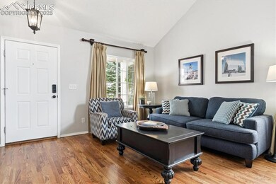 Living room featuring lofted ceiling and wood finished floors