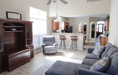Living area with a ceiling fan, visible vents, bas