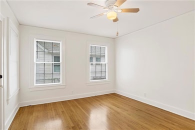 Unfurnished room featuring a ceiling fan, light wo