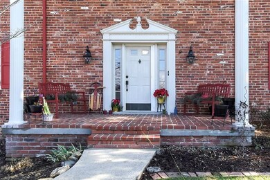 A warm and inviting pillared covered front brick p