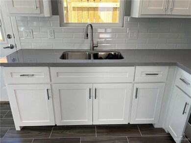 Kitchen featuring sink, tasteful backsplash, and white cabinetry