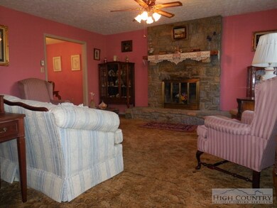 Living room has wood burning fireplace, ceiling fa
