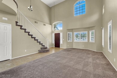Entrance foyer featuring a towering ceiling, carpe