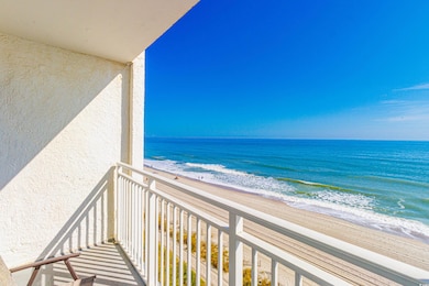 Balcony featuring a beach view and a water view