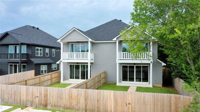 Rear view of property with a shingled roof, a fenc