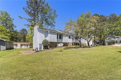 Rear view of property featuring a yard and a chimn