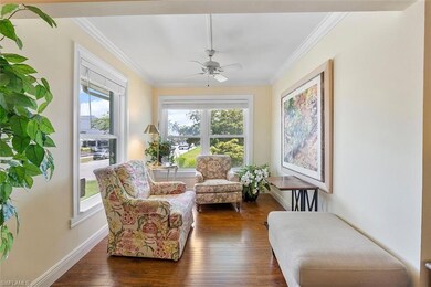 Living area with dark wood-type flooring, crown mo