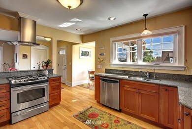 The home's owners lovingly remodeled this beautiful kitchen.  New appliances throughout including the refrigerator, dishwasher, stove, and range hood. There is plenty of counter space for prep and ample cabinetry for storage.  The eat-in nook, with its large windows brings in extra light that keeps the kitchen bright on the grayest of Seattle days.