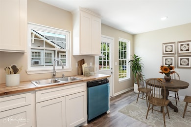 Kitchen featuring dishwasher, white cabinets, sink