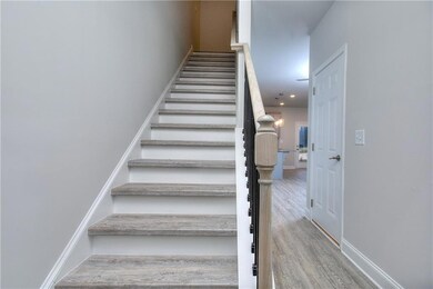 Staircase featuring wood finished floors and a chandelier