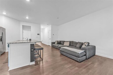 Living room with recessed lighting, dark wood-type flooring, and baseboards