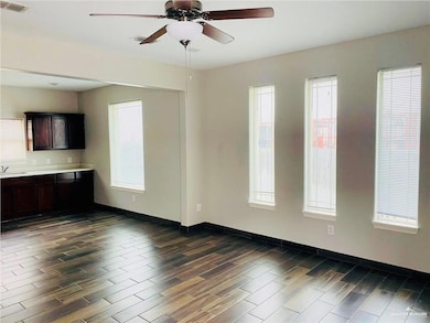 Unfurnished living room featuring a ceiling fan and wood finish floors