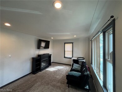 Sitting room with plenty of natural light and dark colored carpet