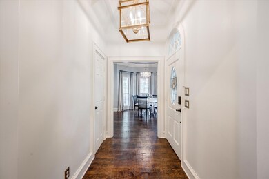 Entry with a custom chandelier and hand-scraped hardwood flooring