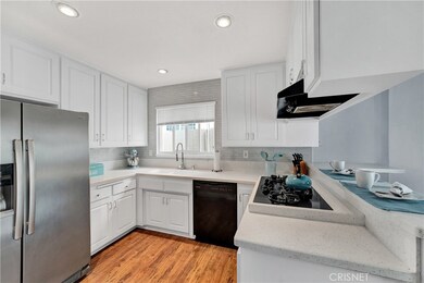 Completely Remodeled Kitchen! Complete with Corian Counters, Custom Backsplash, Fresh Cabinetry & Breakfast Bar!