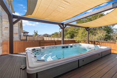 Wooden terrace featuring a hot tub