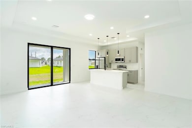 Unfurnished living room featuring a raised ceiling and recessed lighting