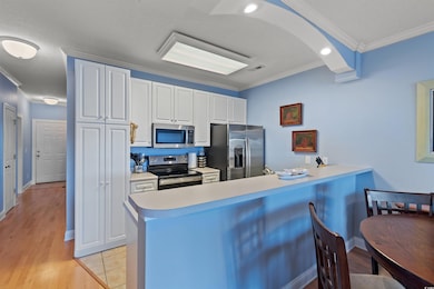 Kitchen featuring a peninsula, ornamental molding,